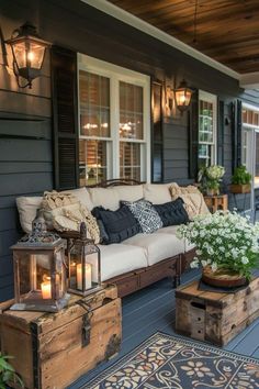 an outdoor living area with couches, coffee table and lanterns on the front porch