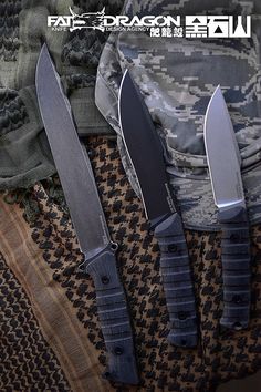 three knives sitting on top of a cloth