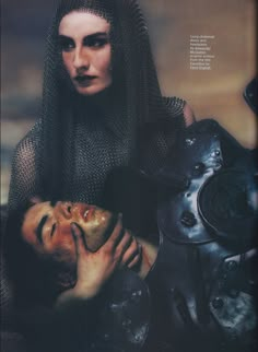 a woman in black is holding a man's head