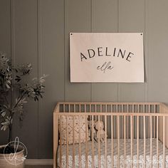 a baby's crib in front of a sign that says adeline