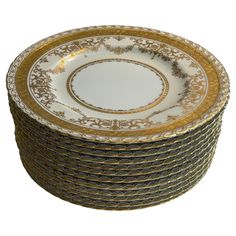 a stack of gold and white plates sitting on top of each other