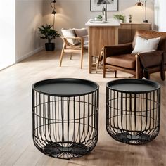 two black wire baskets sitting on top of a hard wood floor next to a chair