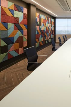 an empty conference room with chairs and paintings on the wall