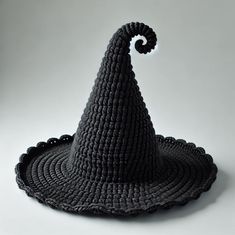 a black crocheted hat with an umbrella on it's brimmed top