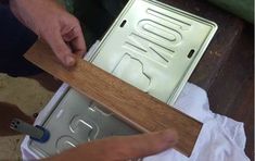 a person is working on a metal and wood sign