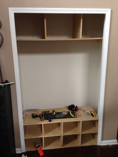 a room with some shelves and tools on the floor next to a wall mounted speaker