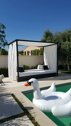 an inflatable duck floating on top of a pool next to a canopy bed