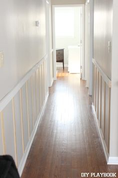 an empty hallway with hard wood floors and white walls