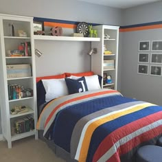 a bedroom with a bed, bookshelf and colorful blanket on the bed in it