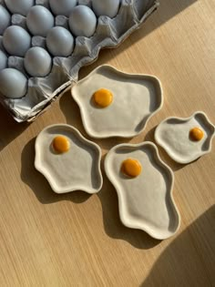 three eggs are sitting in an egg tray on a table next to some other eggs