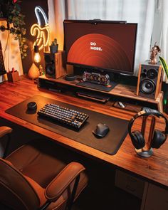 a computer desk with headphones, keyboard and monitor