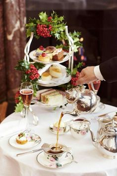 a person pouring tea at a table with food on it