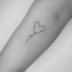 a black and white photo of a heart shaped balloon tattoo on the left arm,