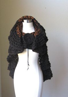 a white mannequin with a black and brown scarf on it's neck