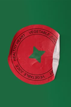 a red and white sticker with a green star in the center that says healthy heart vegetable juice