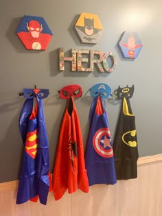 the wall is decorated with superhero capes and name signs for children's rooms