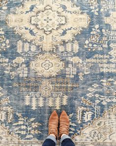 a person standing on top of a rug with their feet in the middle of it