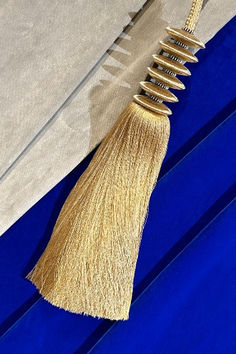 a long tassel hanging from the side of a building with blue walls and windows