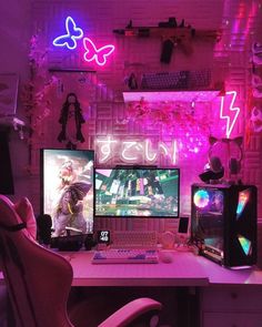 two computer monitors sitting on top of a desk in front of a neon sign that says fun