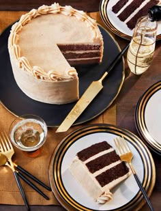 there is a piece of cake on the table with gold and black plates next to it