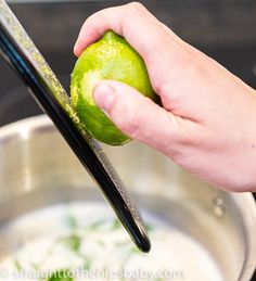 someone is peeling an apple into a bowl