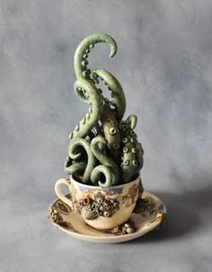 an octopus plant in a teacup on a saucer