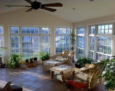 a living room with large windows and lots of furniture in it's center area