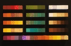 an array of different colored squares are arranged on a black background, with the colors being reflected in them