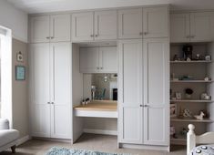 a bedroom with white cupboards and a blue rug