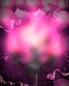 pink balloons are floating in the air over a crowded stadium area with white and purple streamers