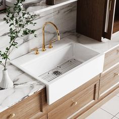 a kitchen with marble counter tops and wooden cabinets, white sink and gold faucet