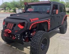 a black and red jeep parked in a parking lot