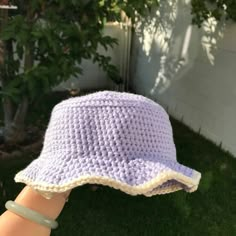 a crocheted hat is held up in the air by someone's hand