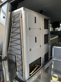 the back end of a van with its door open and shelves in place for pizza