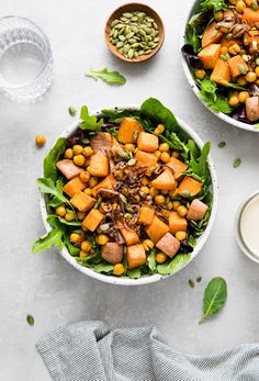 two bowls filled with salad next to a glass of milk