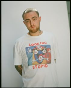 a man wearing a mickey mouse t - shirt looking at the camera with an angry look on his face