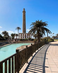 a light house sitting on top of a lush green field next to a swimming pool