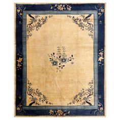 an antique rug with blue border and floral design on the center, in cream ground