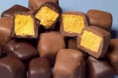 a pile of chocolates with yellow frosting on top and the words homemade cadbury crunches above them