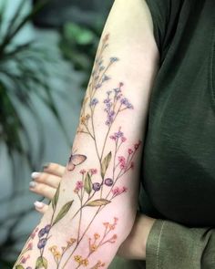 a woman's arm with flowers painted on it