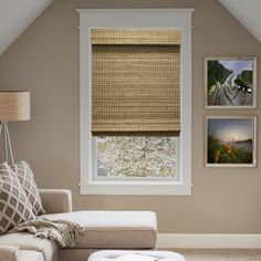 a living room with a couch, window and pictures on the wall above it's windows