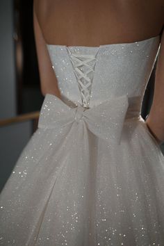 the back of a white wedding dress with sequins on it's waist