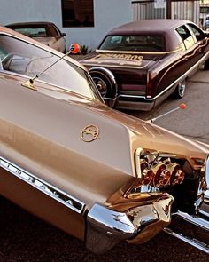 an old car parked on the side of the road with other cars in the background