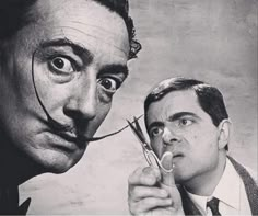 two men with fake mustaches holding scissors in front of their face and looking at the camera