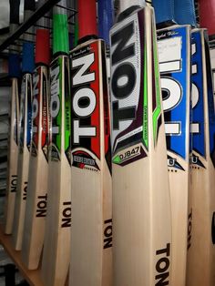 several wooden baseball bats lined up on a rack in a room with other bat's