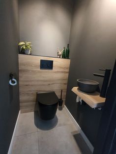 a bathroom with a toilet, sink and wooden paneling on the wall behind it