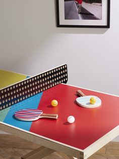 a ping pong table with paddles and balls on it