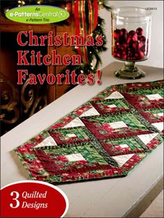 the table runner is decorated with red, green and white quilted squares on it