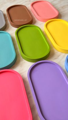 several different colored trays sitting on top of a table