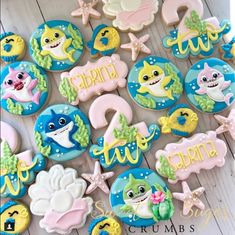 some decorated cookies are sitting on a wooden table with the words shark and sea animals